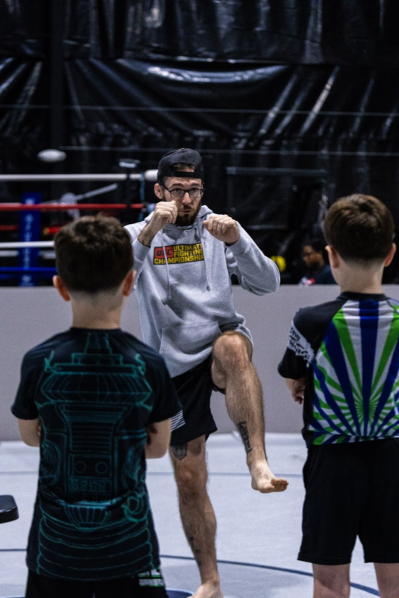 Coach demonstrating a knee drill while two young students watch closely