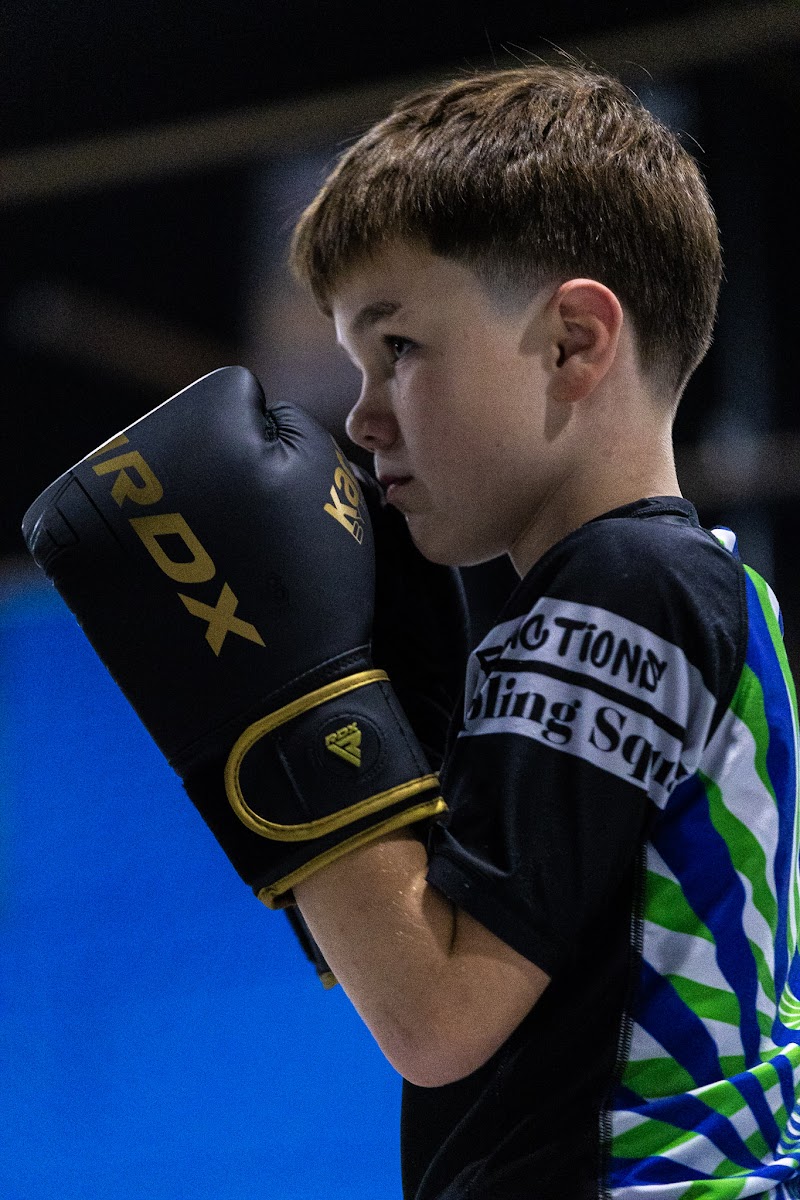 Young student in boxing gloves with a focused, determined look